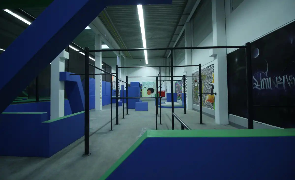Ein großer Indoor-Trampolinpark mit bunten Bällen in verschiedenen Farben, die überall verteilt sind.
