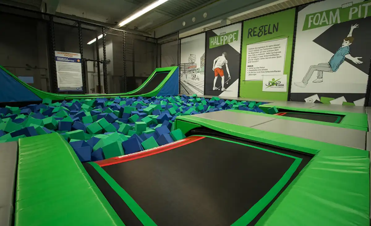 Ein Trampolinpark mit einer großen grünen Fläche, die zum Springen und Spielen einlädt.