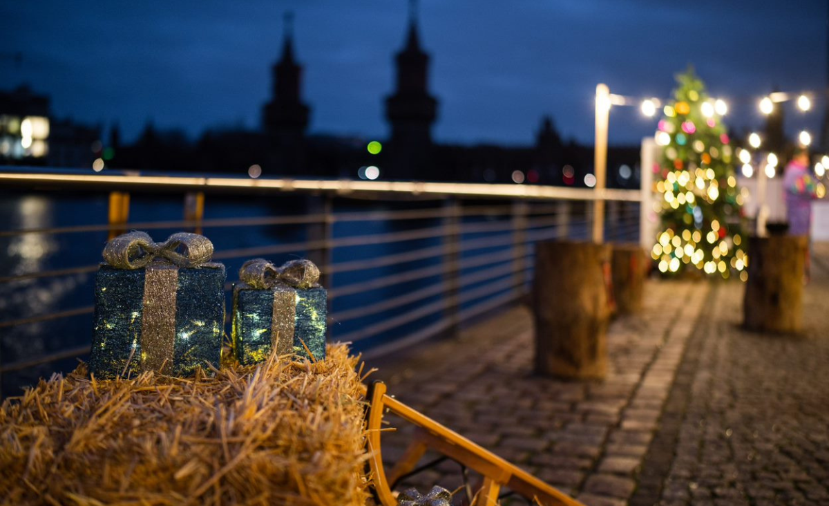 Weihnachtslichter auf einem Holztisch neben einem Fluss, der eine festliche und
