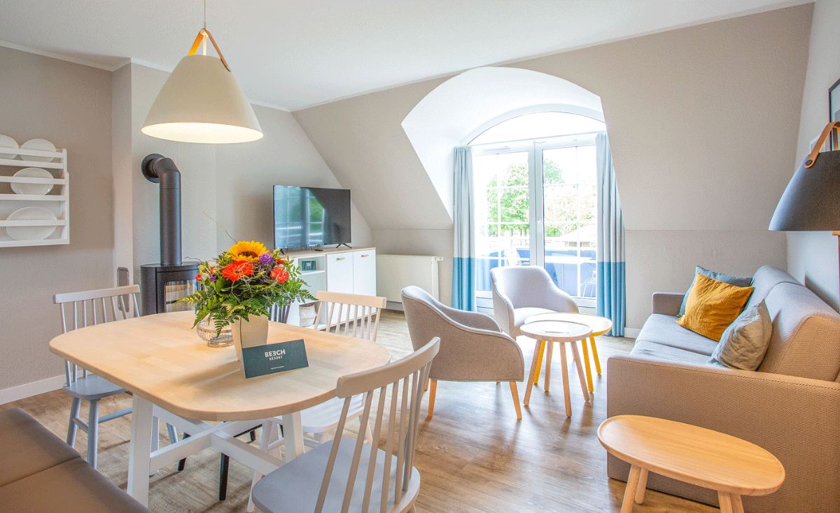 Ein Wohnzimmer mit einem Tisch und Stühlen, das eine einladende und gemütliche Atmosphäre ausstrahlt.