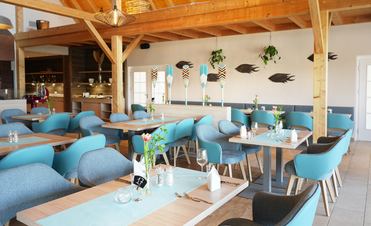 Ein Restaurant mit blauen Stühlen und Tischen, das eine einladende Atmosphäre schafft.