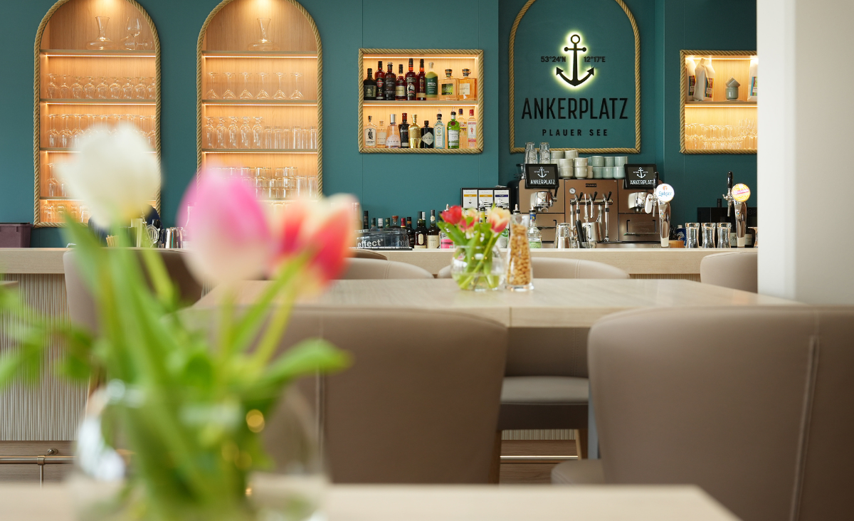 Ein Restaurant mit einer Bar und Tischen, das eine einladende Atmosphäre für Gäste bietet.