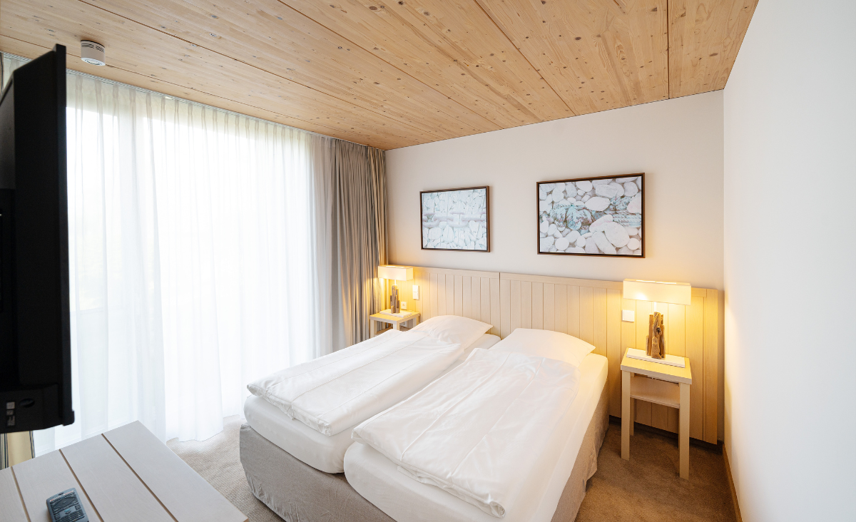 Ein gemütliches Schlafzimmer mit zwei Betten und einem Fernseher, ideal für entspannte Nächte und gemeinsame Zeit.