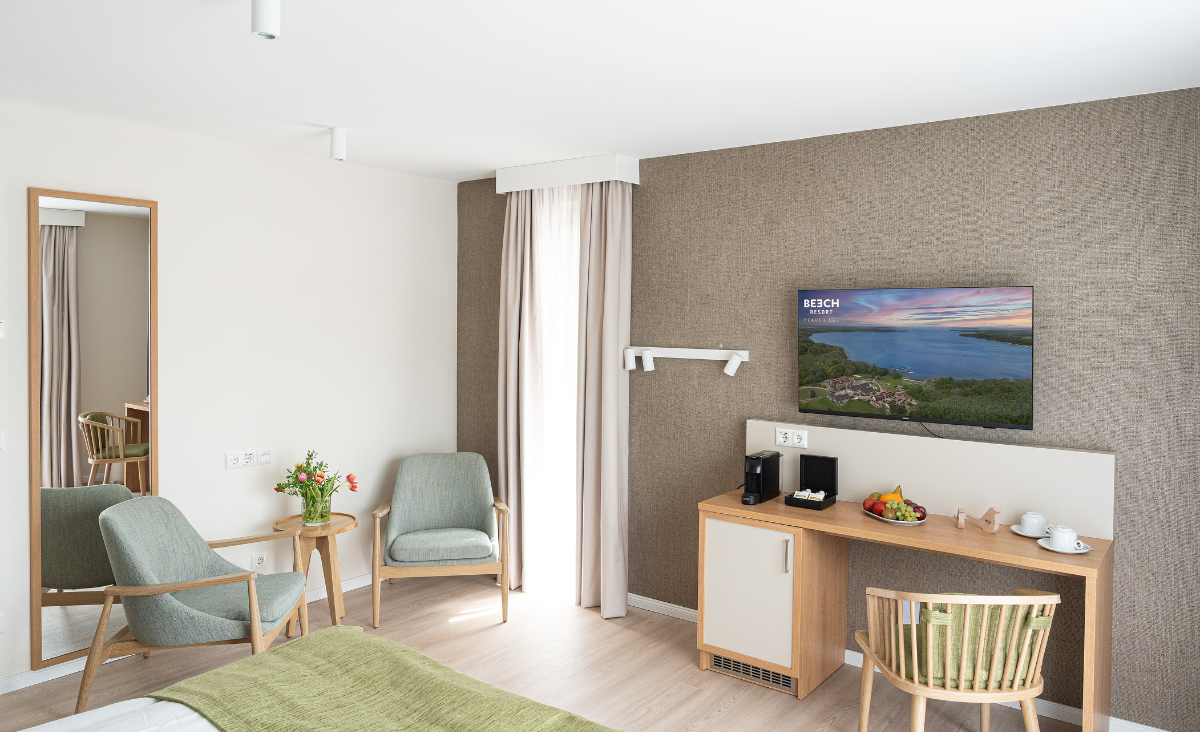 Ein gemütliches Schlafzimmer mit einem Schreibtisch und einem Fernseher, ideal zum Entspannen und Arbeiten.