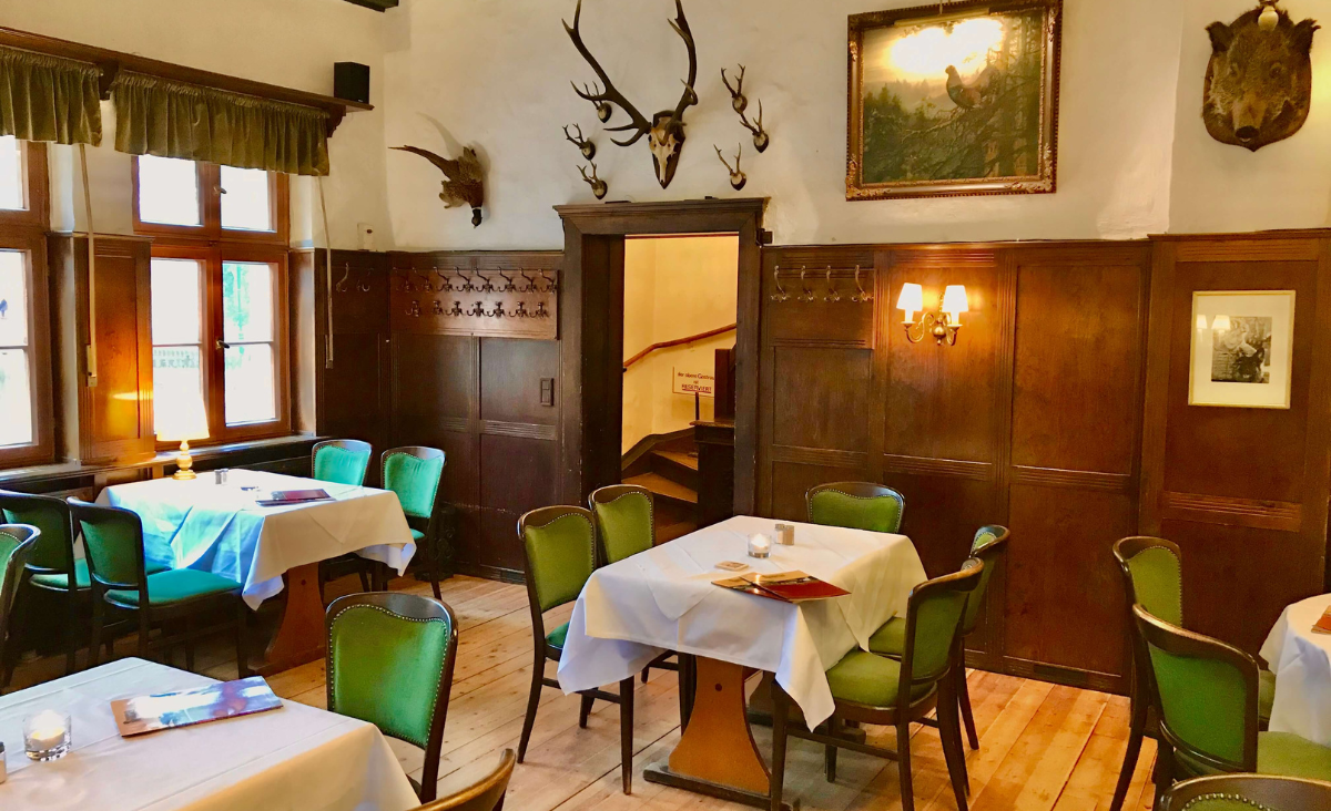 Innenansicht eines Restaurants mit stilvollen Tischen und Stühlen, bereit für Gäste.