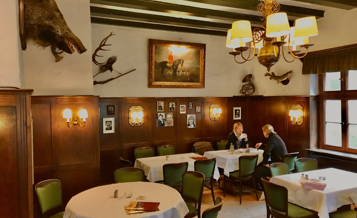 Ein Restaurant mit stilvollen Tischen und Stühlen in einem hellen Raum, perfekt für entspannte Mahlzeiten und Gespräche.
