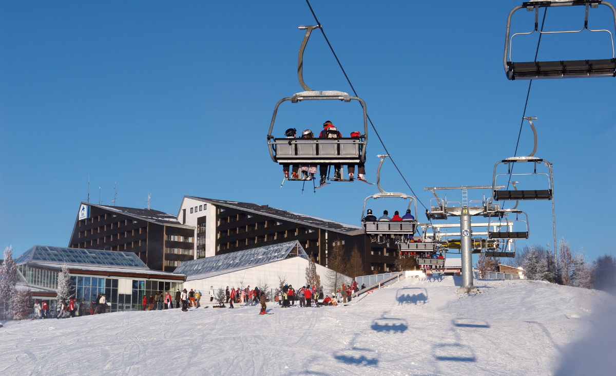 Eine Skiliftanlage mit mehreren Personen, die auf den Sitzen sitzen und die Aussicht genießen.