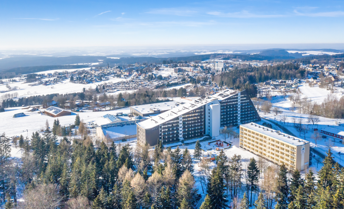 Ein Hotel, umgeben von schneebedeckten Bäumen, strahlt eine ruhige und malerische Winteratmosphäre aus.