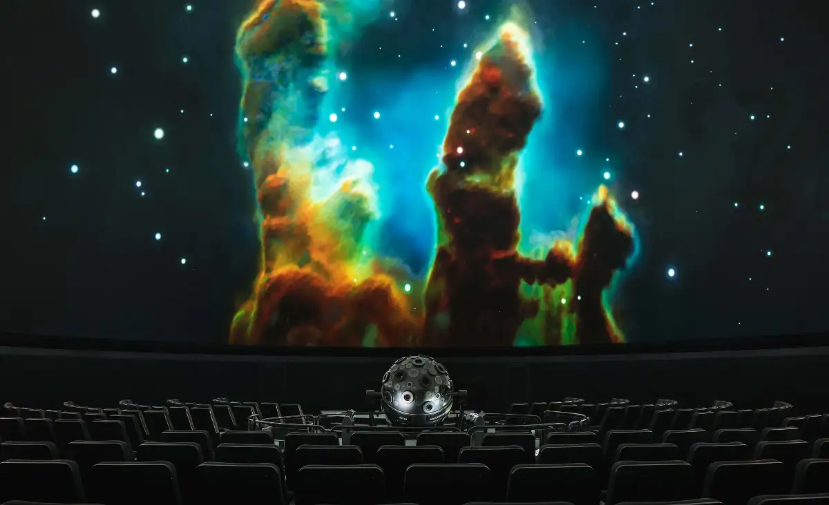 Großbildschirm im Planetarium Berlin mit einer farbenfrohen Nebelansicht im Hintergrund.