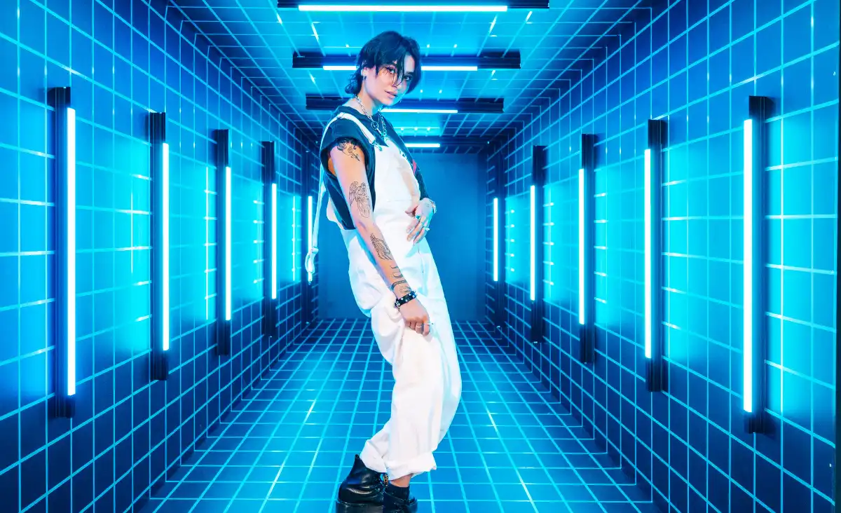 Eine Frau in einem weißen Outfit steht in einem blauen Tunnel.
