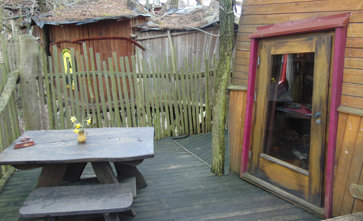 Holzterrasse mit einem Tisch und Stühlen, ideal für entspannte Stunden im Freien.
