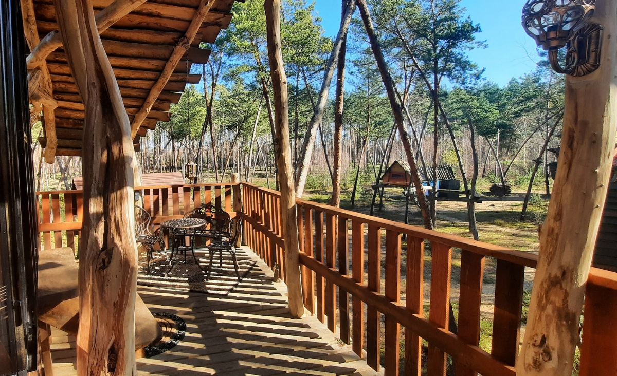 Gemütliches Holzdeck, ausgestattet mit einem Tisch und Stühlen für gesellige Zusammenkünfte.