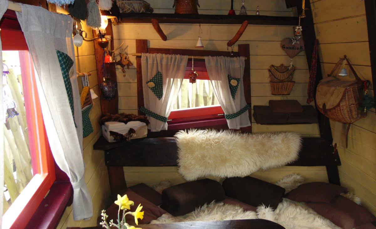 Ein gemütlicher Raum mit einem Bett, einem Tisch und einem Fenster, das Tageslicht hereinlässt.