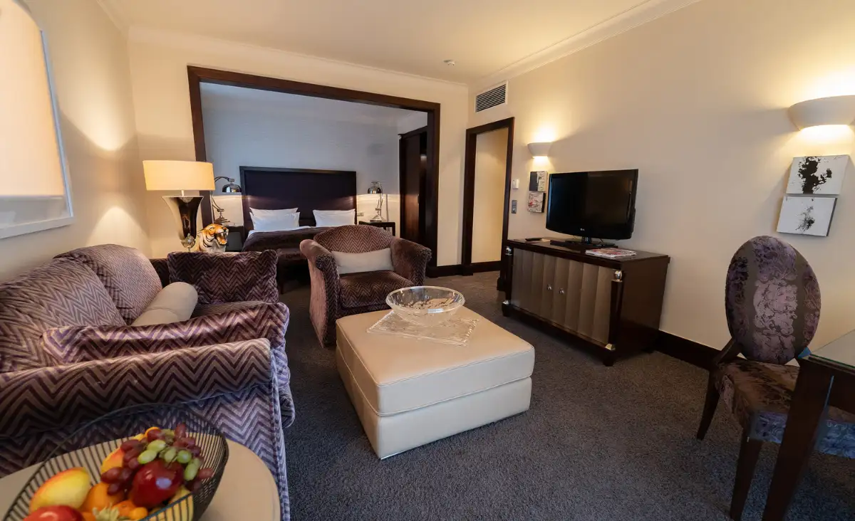 Einladendes Wohnzimmer mit Couch, Stuhl, Tisch und Fernseher auf einem stilvollen TV-Regal.