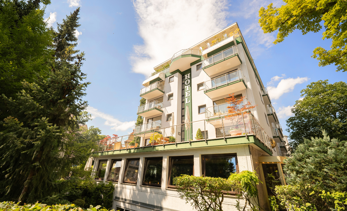 Hotel Bernstein Villa Kastania, mit einer malerischen Baumlandschaft im Hintergrund.