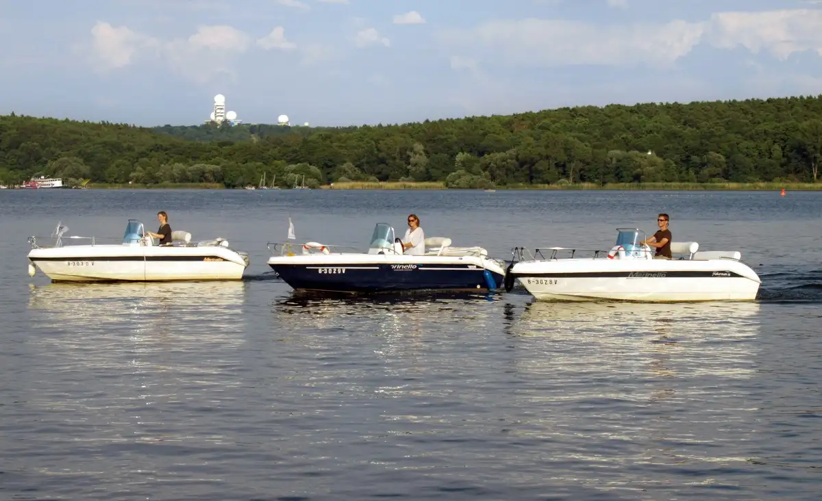 Eine Gruppe von Menschen auf Booten, die fröhlich auf dem Wasser unterwegs sind.