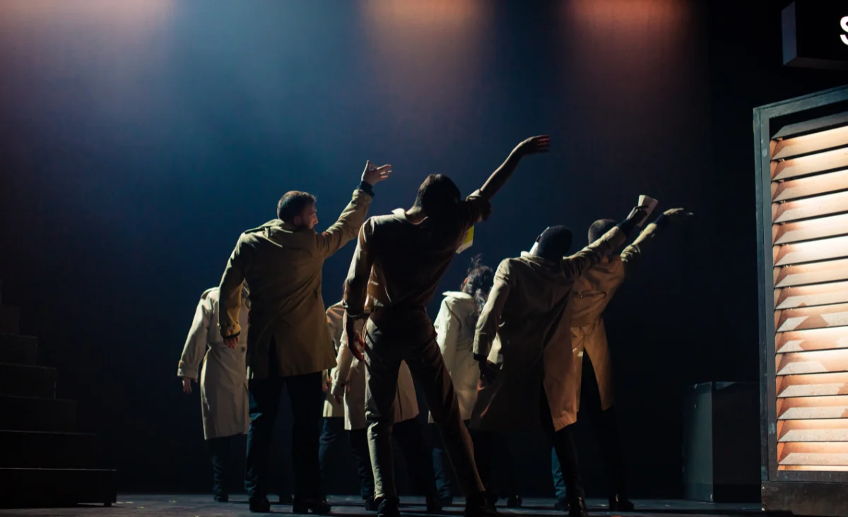 Eine Gruppe von Menschen in einem dunklen Raum, die verschiedene Tanzstile von klassisch bis modern präsentieren.