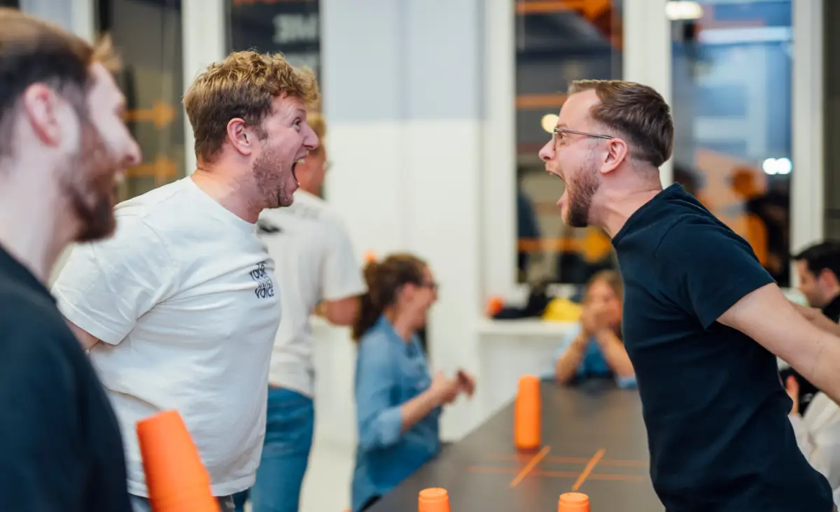 Zwei lachende Männer spielen ein Spiel im your showdown und nutzen ihren Gutschein für Game Showdown in Düsseldorf.