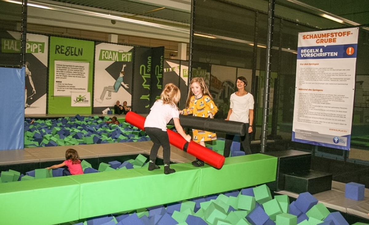 Eine Gruppe von Kindern springt fröhlich auf einem Trampolin in der Indoor-Spielarena Jum3000 in Berlin.
