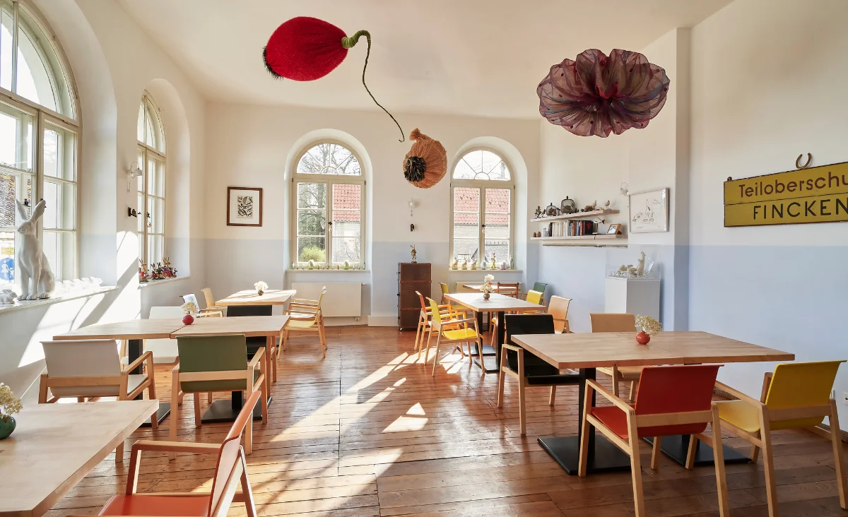 Ein Restaurant mit bunten Stühlen und Tischen, das eine einladende und lebendige Atmosphäre schafft.