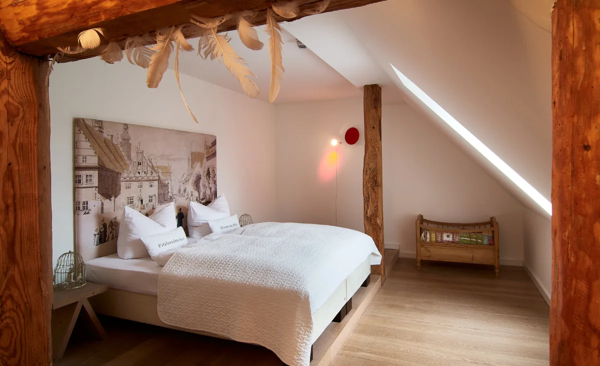Ein Schlafzimmer mit einem Bett und einem Holzträger, das eine gemütliche und rustikale Atmosphäre ausstrahlt.