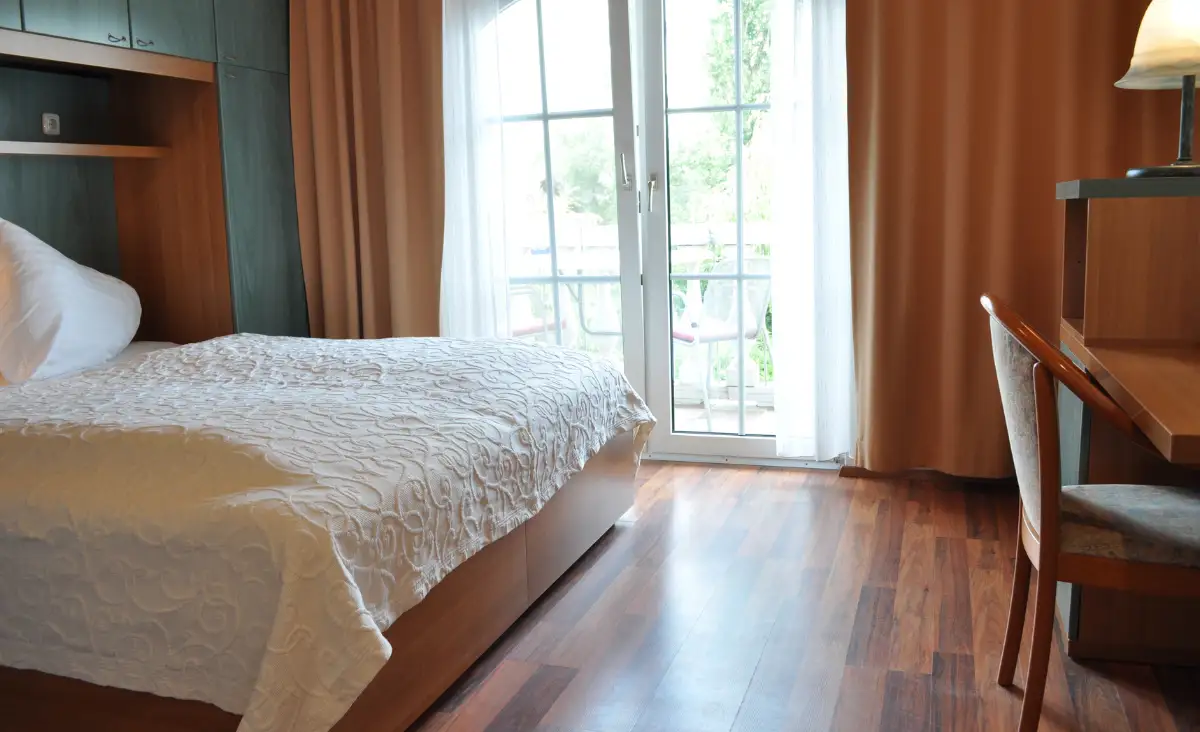 Das Bett im Seehotel Herlinde ist perfekt gemacht, strahlt Eleganz und Komfort aus.