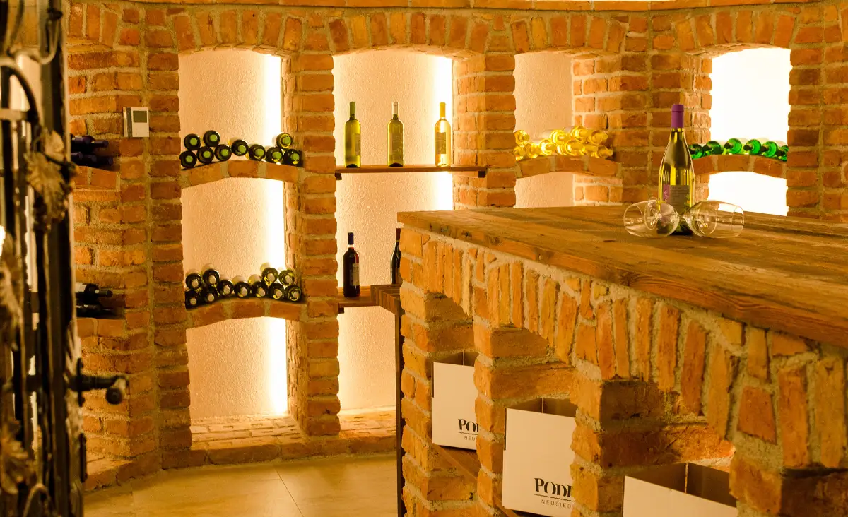 Eine elegante Weinkeller-Bar im Seehotel Herlinde, umgeben von erlesenen Weinflaschen in stilvollen Regalen.