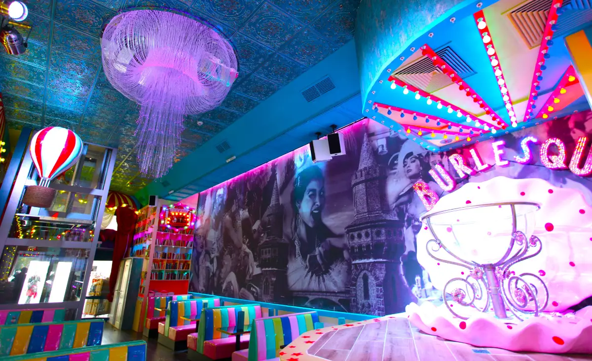 Buntes Restaurant mit Neonlichtern und großem Kronleuchter im Cirque du Burlesque, Lieschen Mueller, Berlin.