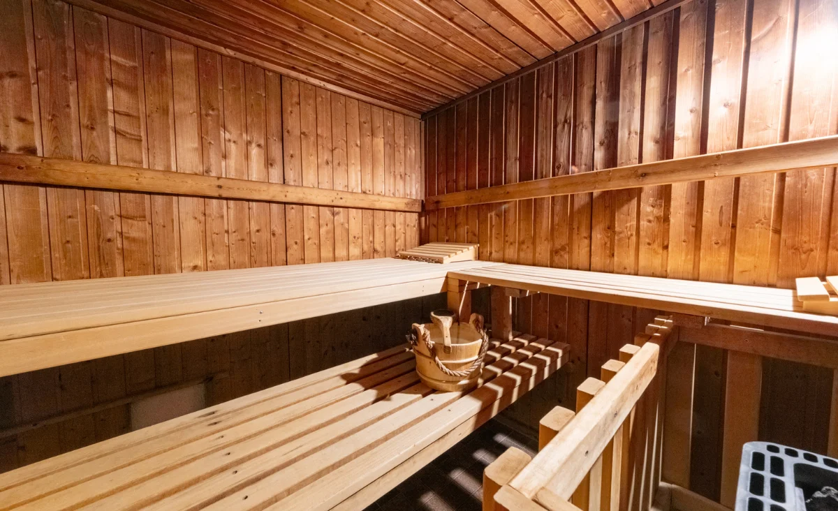 Eine Sauna mit Holzwänden und Holzbank, die eine entspannende Atmosphäre für Erholung und Wellness bietet.