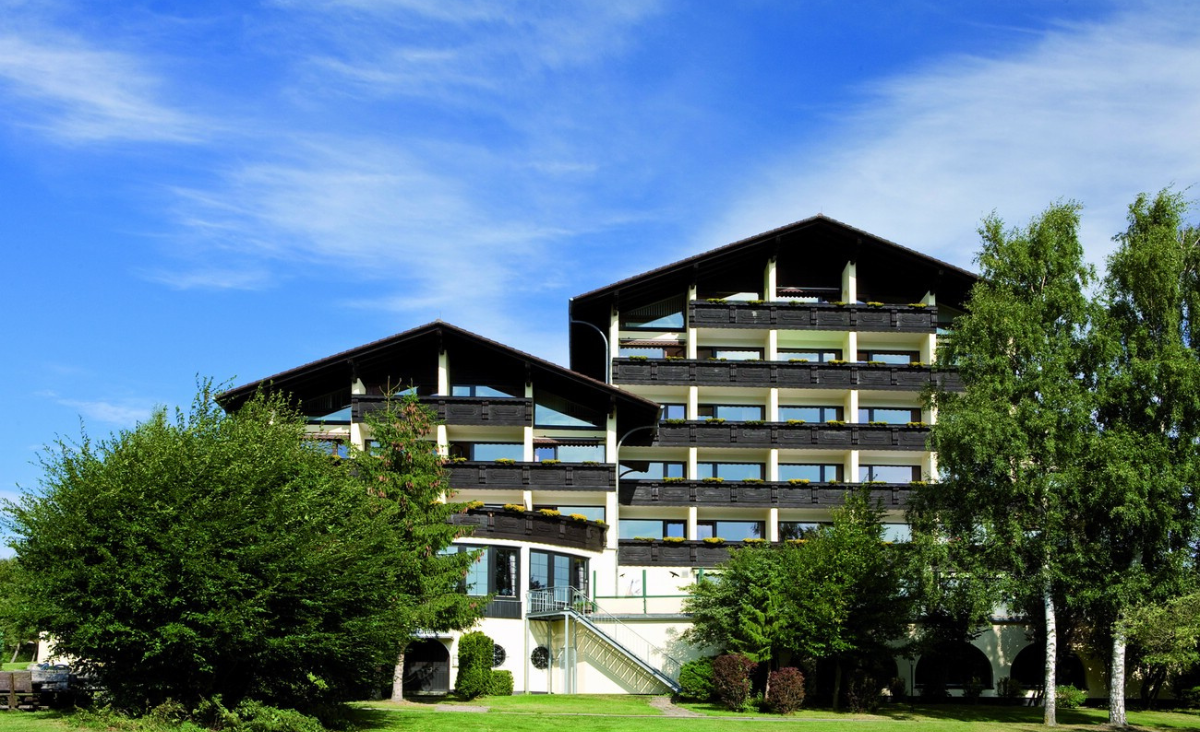 Ein Hotel inmitten eines üppigen, grünen Feldes, umgeben von Natur und Ruhe.