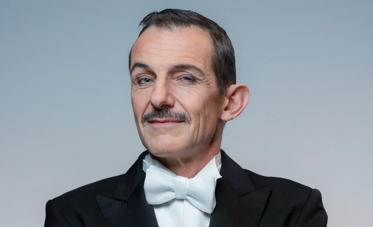 Ein elegant gekleideter Mann in einem schwarzen Smoking mit einer weißen Fliege.