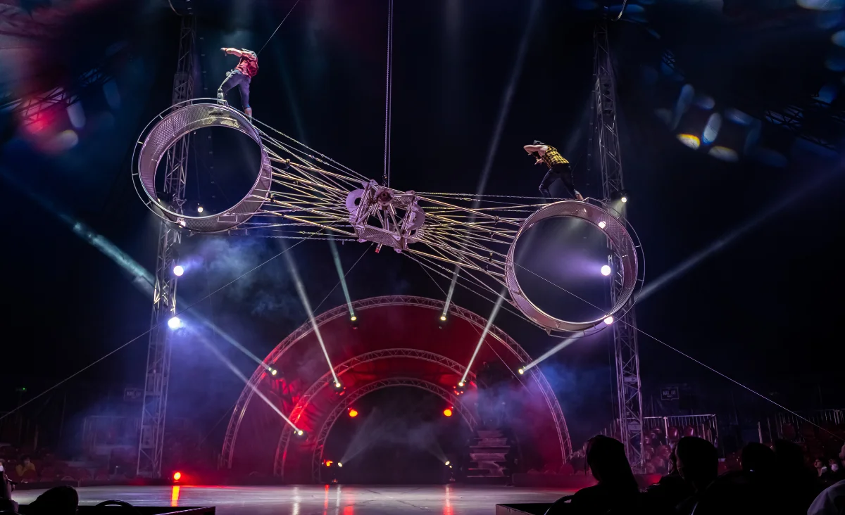 Zirkusartisten führen auf einer Bühne mit Rauch aus den Ringen eine beeindruckende Darbietung im "Zirkus des Horrors" auf.
