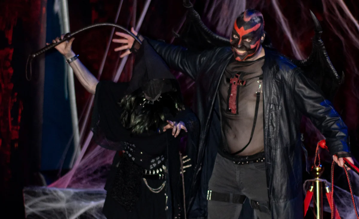 Ein Mann und eine Frau in Schwarz mit Masken, die für den Zirkus des Horrors Memento Mori in Berlin posieren.