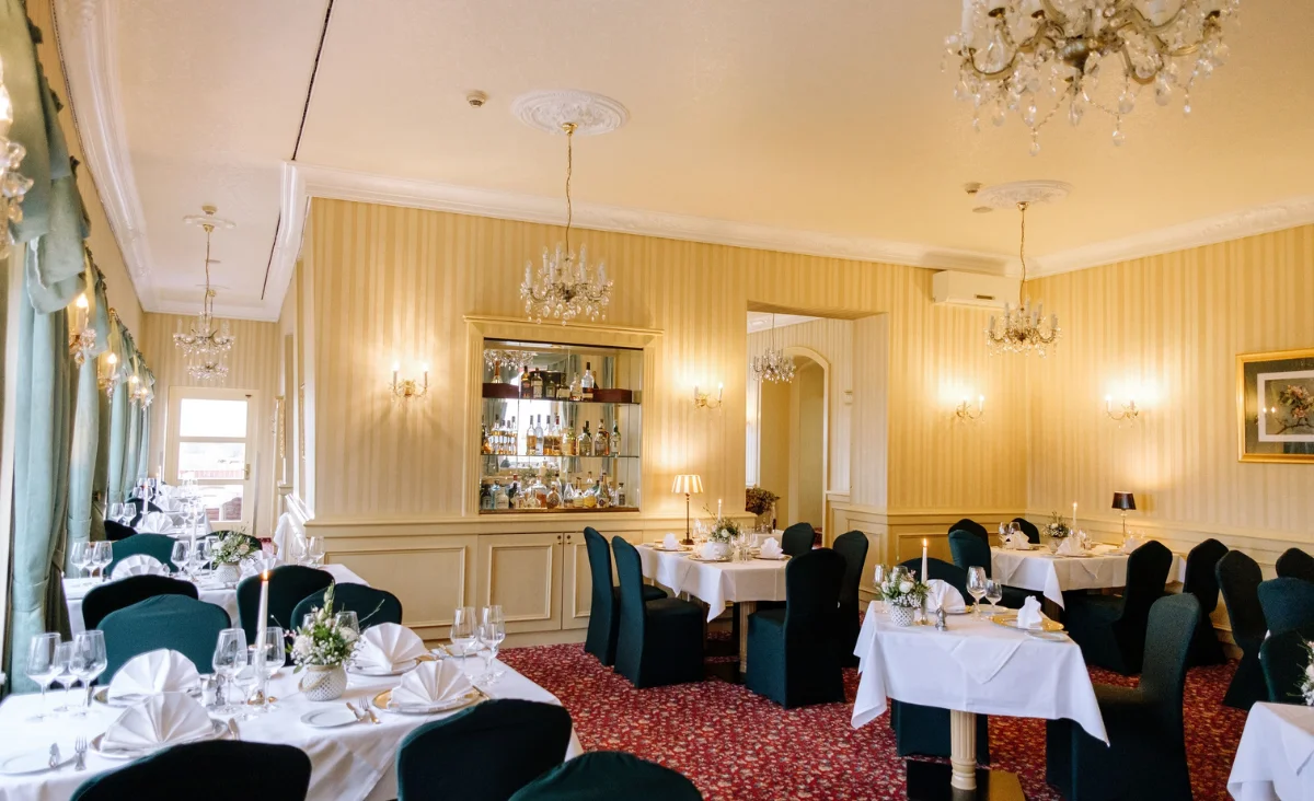 Ein Restaurant mit gedeckten Tischen und Stühlen, bereit für das Abendessen.