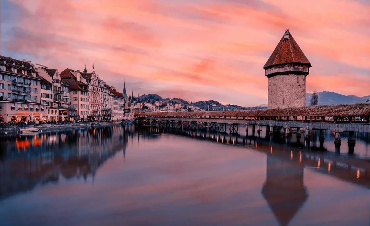 Brücke über den Vierwaldstättersee, umgeben von einem farbenfrohen Himmel.
