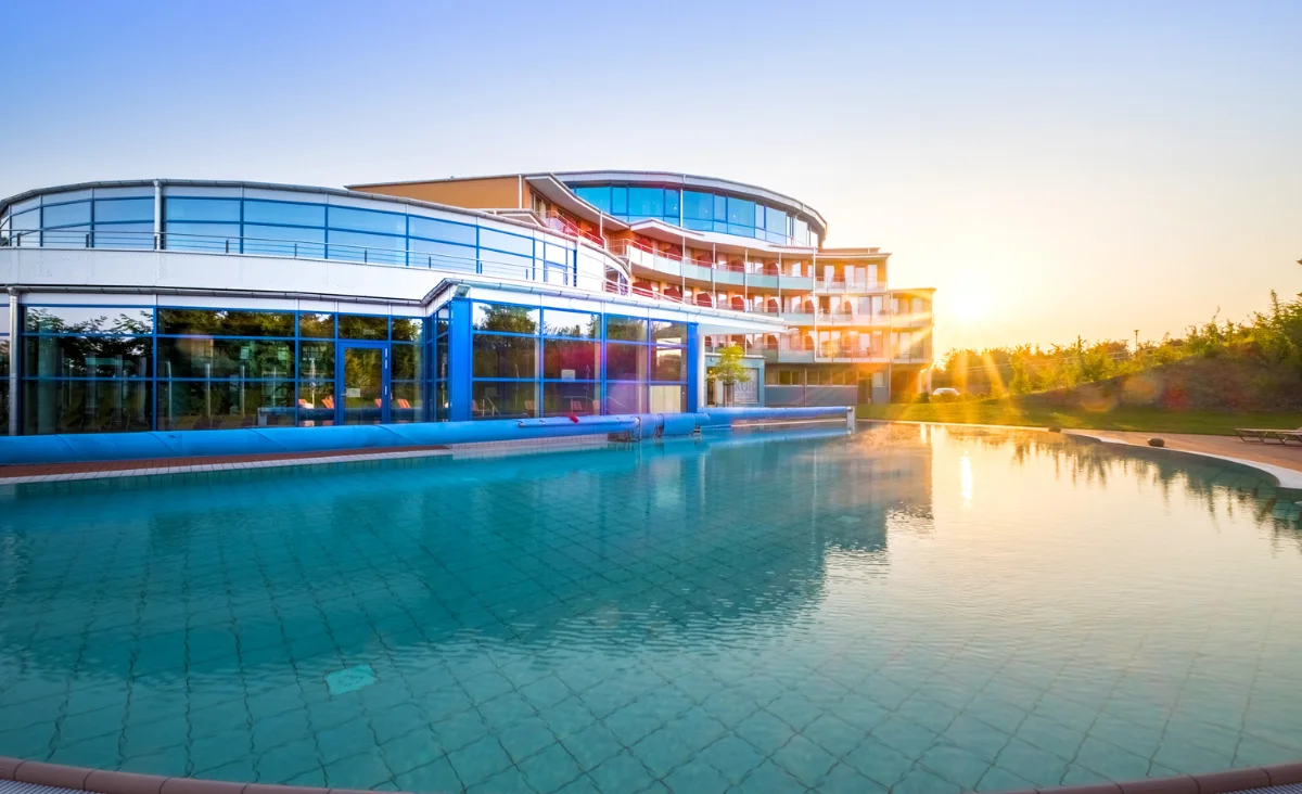 Weitläufiger Swimmingpool vor einem modernen Gebäude, ideal für Erholung und Freizeit.
