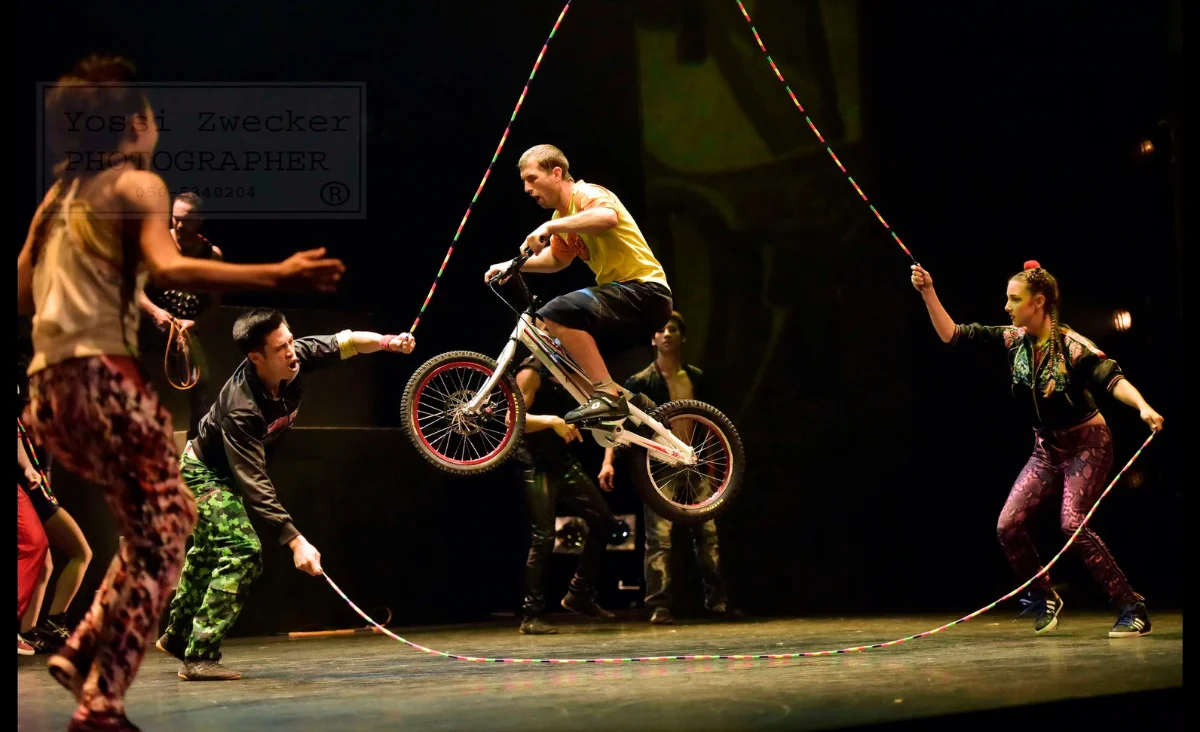 Auf der Bühne von Cirque Éloize vollbringt ein Mann auf dem Fahrrad einen beeindruckenden Trick.