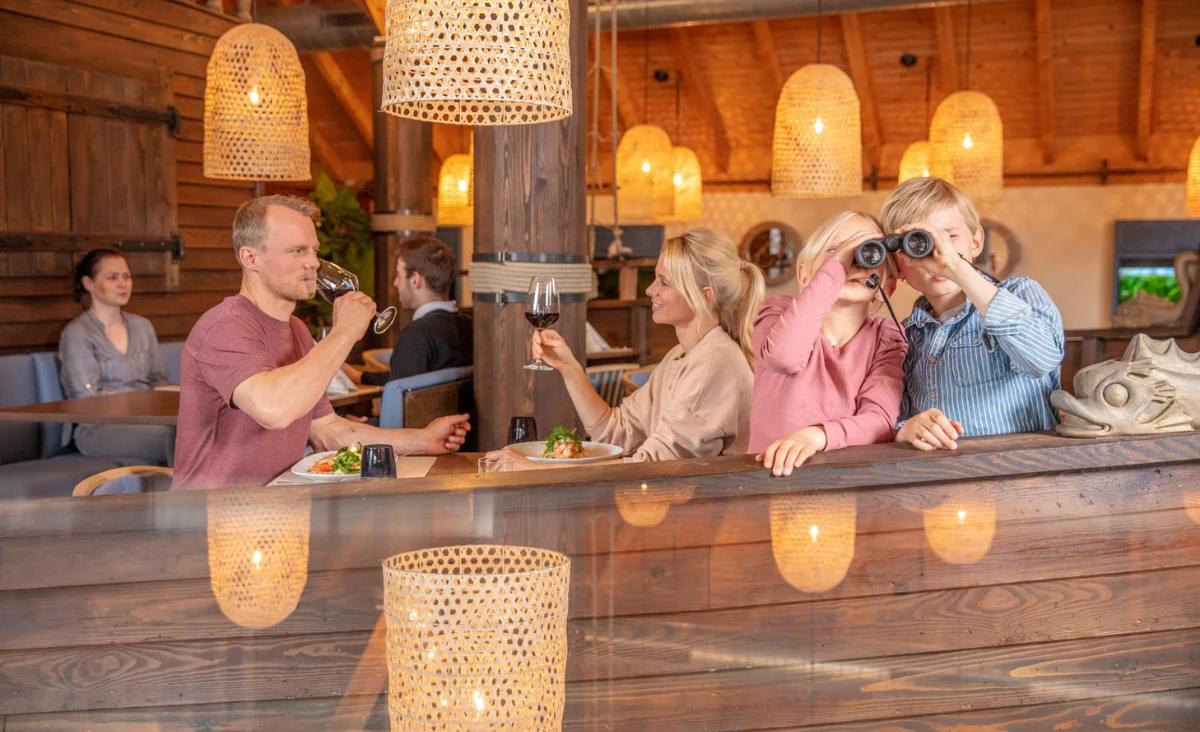 Familie genießt ein gemeinsames Essen in einem Restaurant während ihres Urlaubs an der Mecklenburgischen Seenplatte.