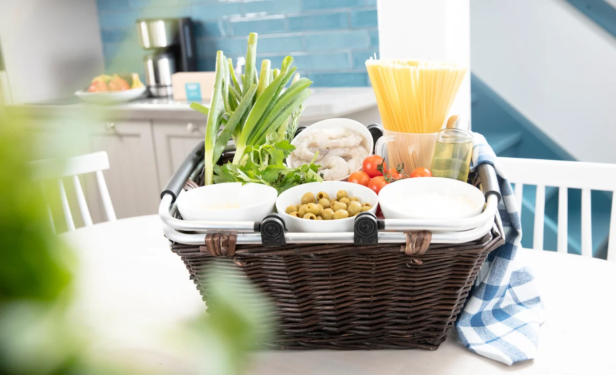 Ein Korb mit verschiedenen Lebensmitteln auf einem Tisch, ideal für ein Familienpicknick an der Mecklenburgischen Seenplatte.