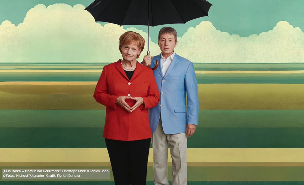 Schauspieler unter einem Regenschirm, die 'Miss Merkel in der Komödie am Kurfürstendamm' aufführen.