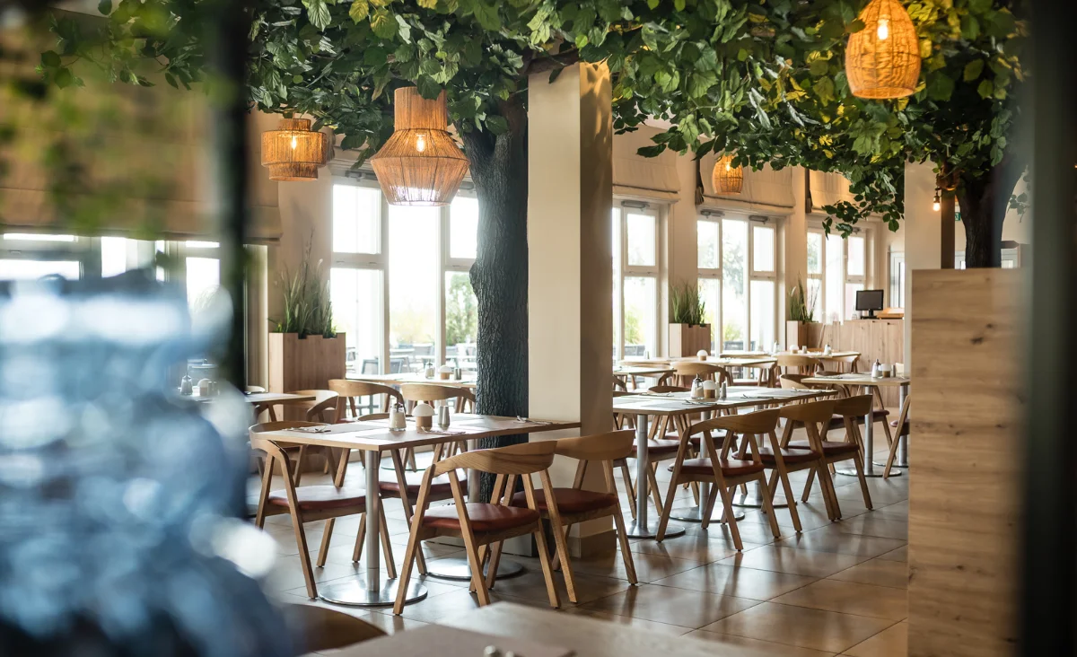 Ein Restaurant mit Tischen und Stühlen in der Mitte des Raumes, ideal für einen Familienurlaub an der Ostsee.