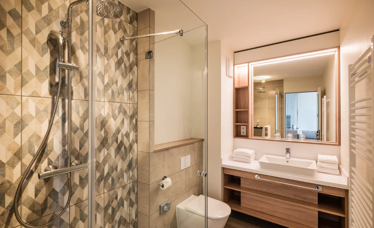 Badezimmer mit Dusche, Toilette und Waschbecken, ideal für einen Familienurlaub an der Ostsee.