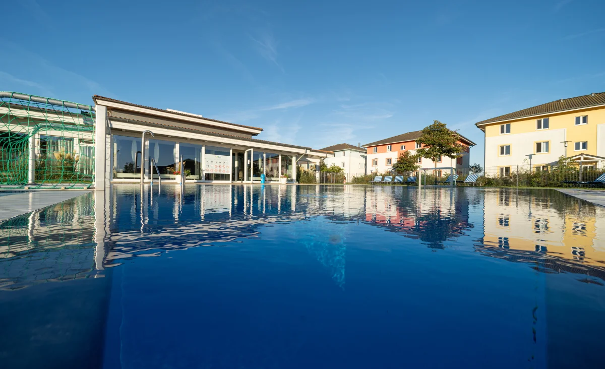 Ein großer Swimmingpool vor einem Gebäude, ideal für einen Familienurlaub an der Ostsee.