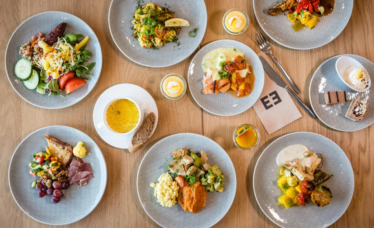 Ein Tisch mit verschiedenen Tellern voller Essen, ideal für einen Familienurlaub an der Ostsee.