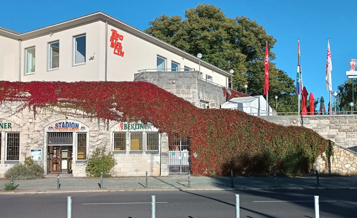 Eine Fassade des Stadionterrassen-Gebäudes mit rotem Efeu, der die Wand bedeckt.