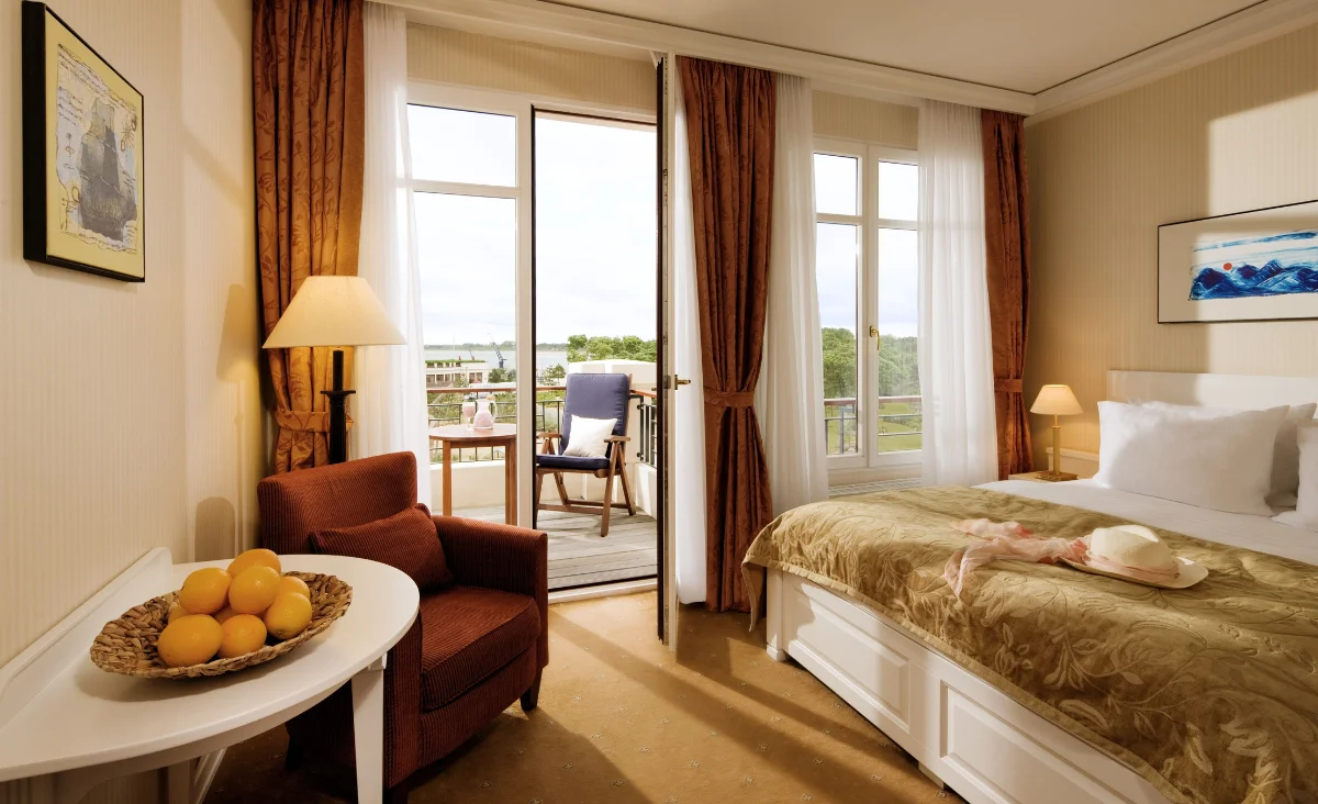 Gemütliches Bett mit weißer Bettdecke in der Yachthafenresidenz Hohe Düne.