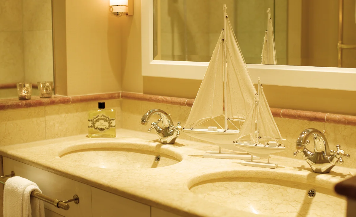Badezimmer mit Waschbecken und Spiegel in der Yachthafenresidenz Hohe Düne.