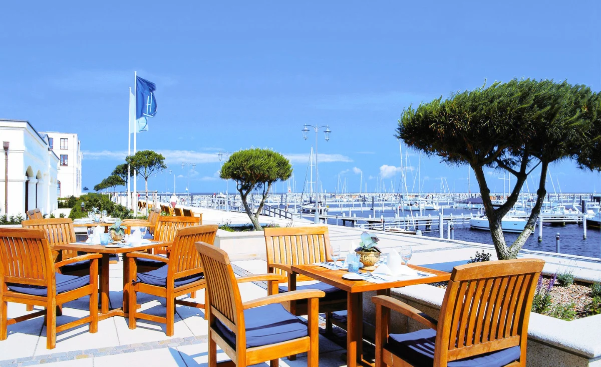 Ein Tisch mit vier Stühlen im Yachthafenresidenz Hohe Düne, ideal für gesellige Zusammenkünfte.