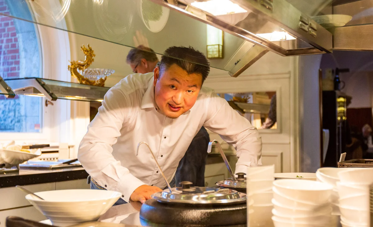 Ein Mann in einem weißen Hemd steht in Zhou's Fine im Ratskeller Reinickendorf.