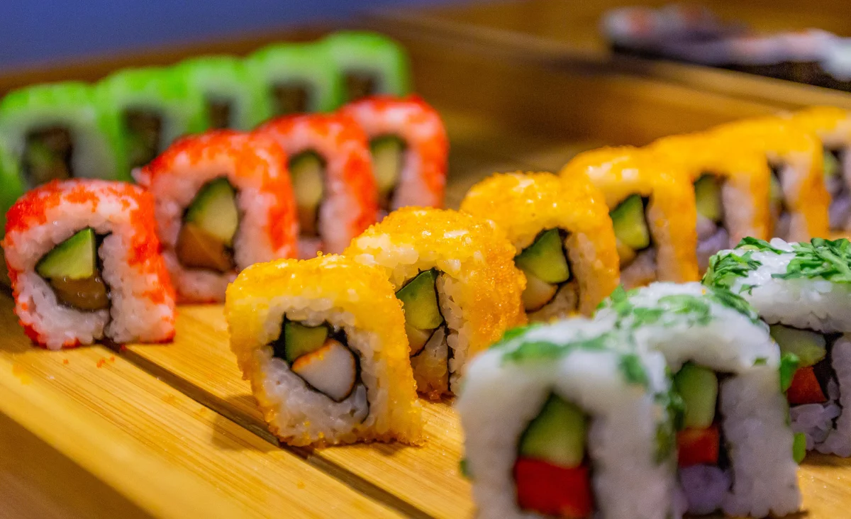 Sushi-Rollen auf einem Holztablett im Zhou's Fine im Ratskeller Reinickendorf arrangiert.
